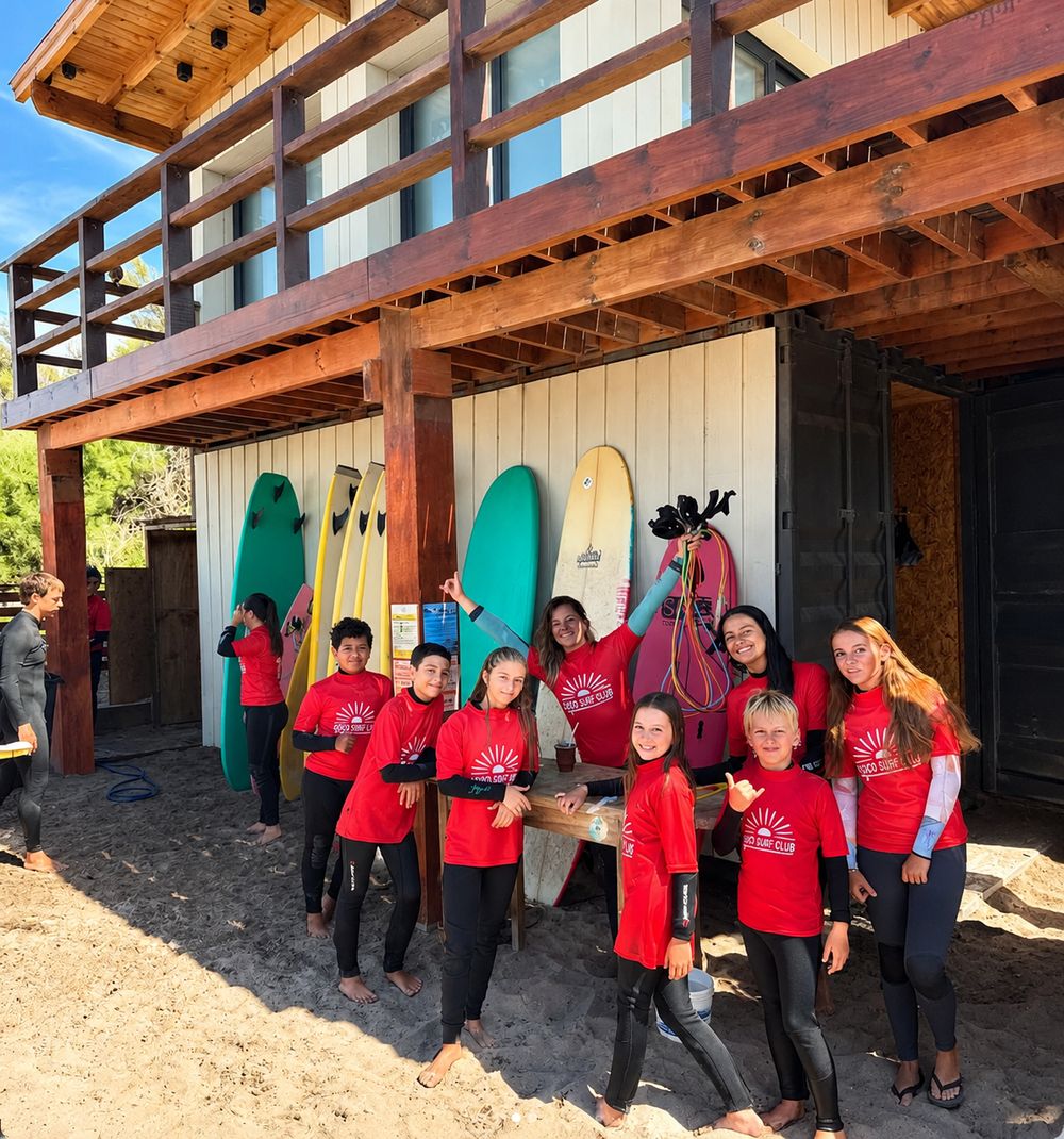 Chicos con remeras rojas de Coco Surf Club frente a la escuela